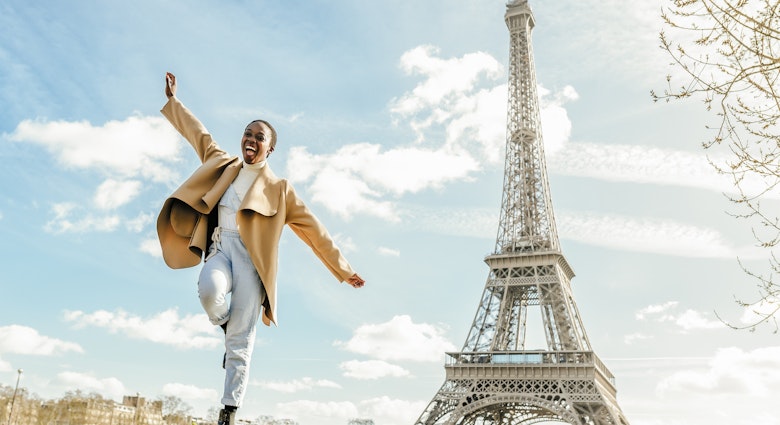 A Black woman dancing near the Eiffel Tower in Paris