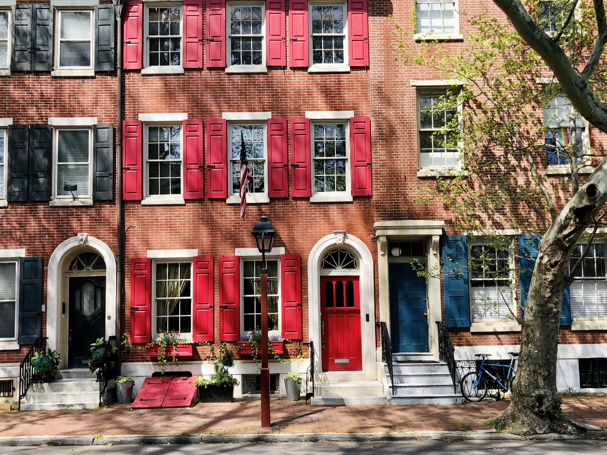 An attractive row of large terraced red-brick houses on a street