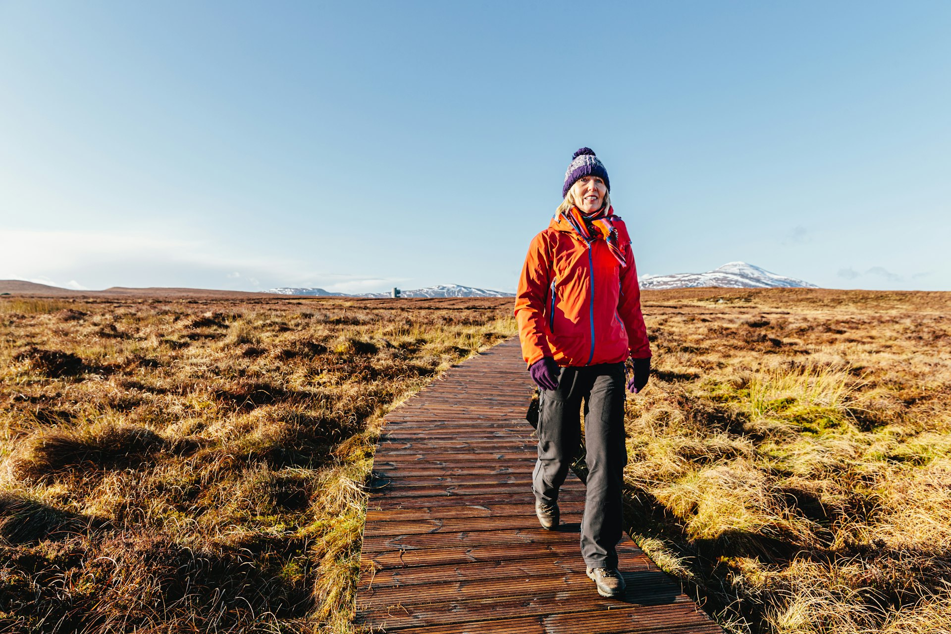 Senior woman on the wooden walkway over the peat bogs at Forsinard, Sutherland, Scotland