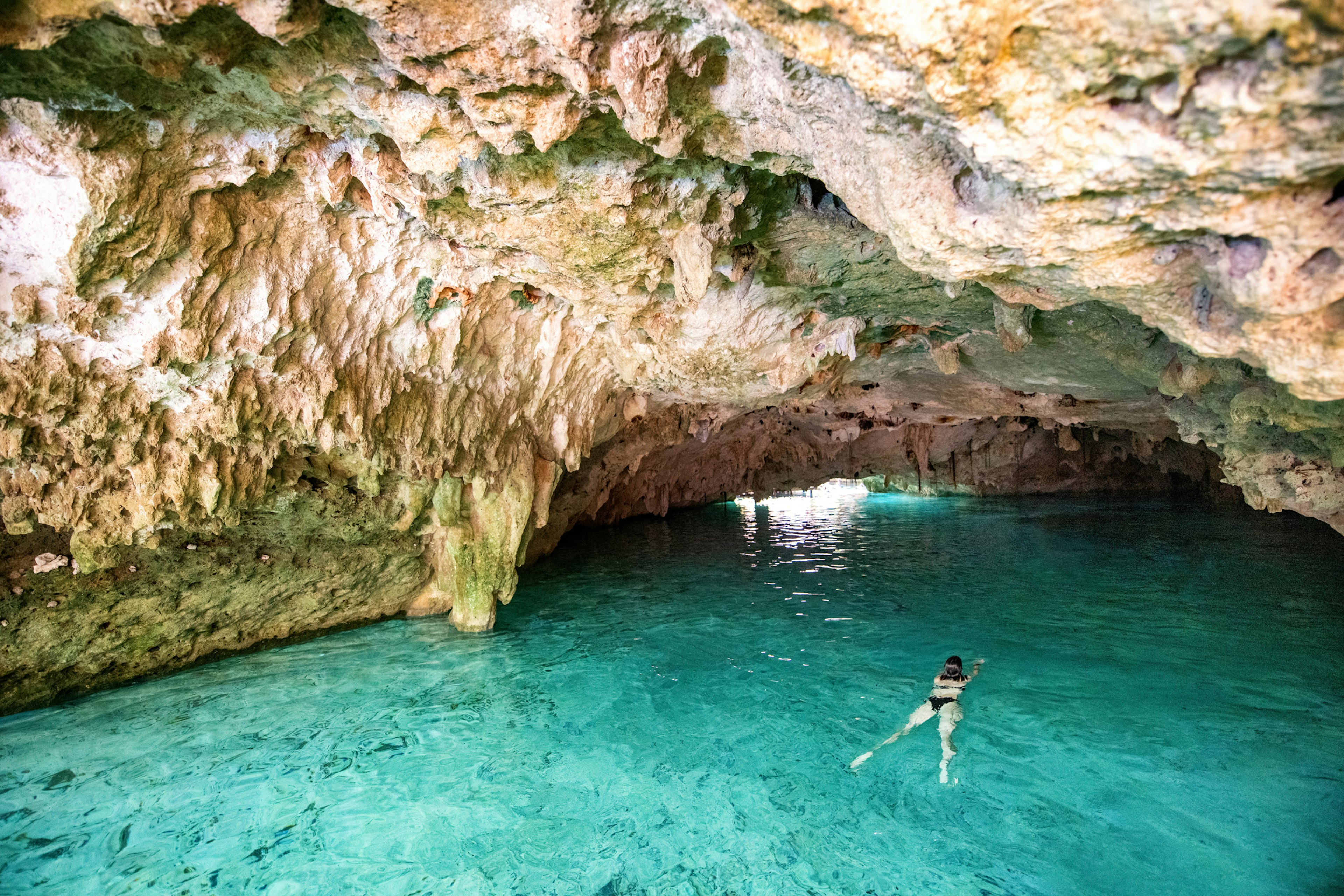 Woman swimming in freshwater in a cave