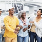 A black family walking along the waterfront and laughing together in Florida