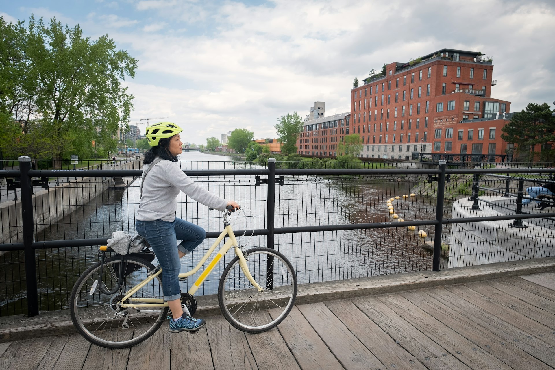 A woman bicycles over Lachine Canal, Montréal, Québec, Canada