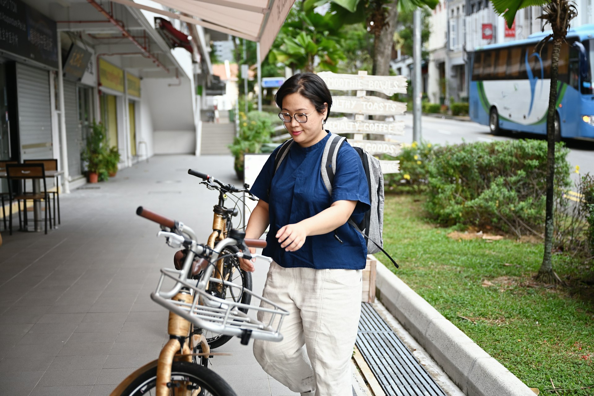 A woman with a backpack approaches a bicycle