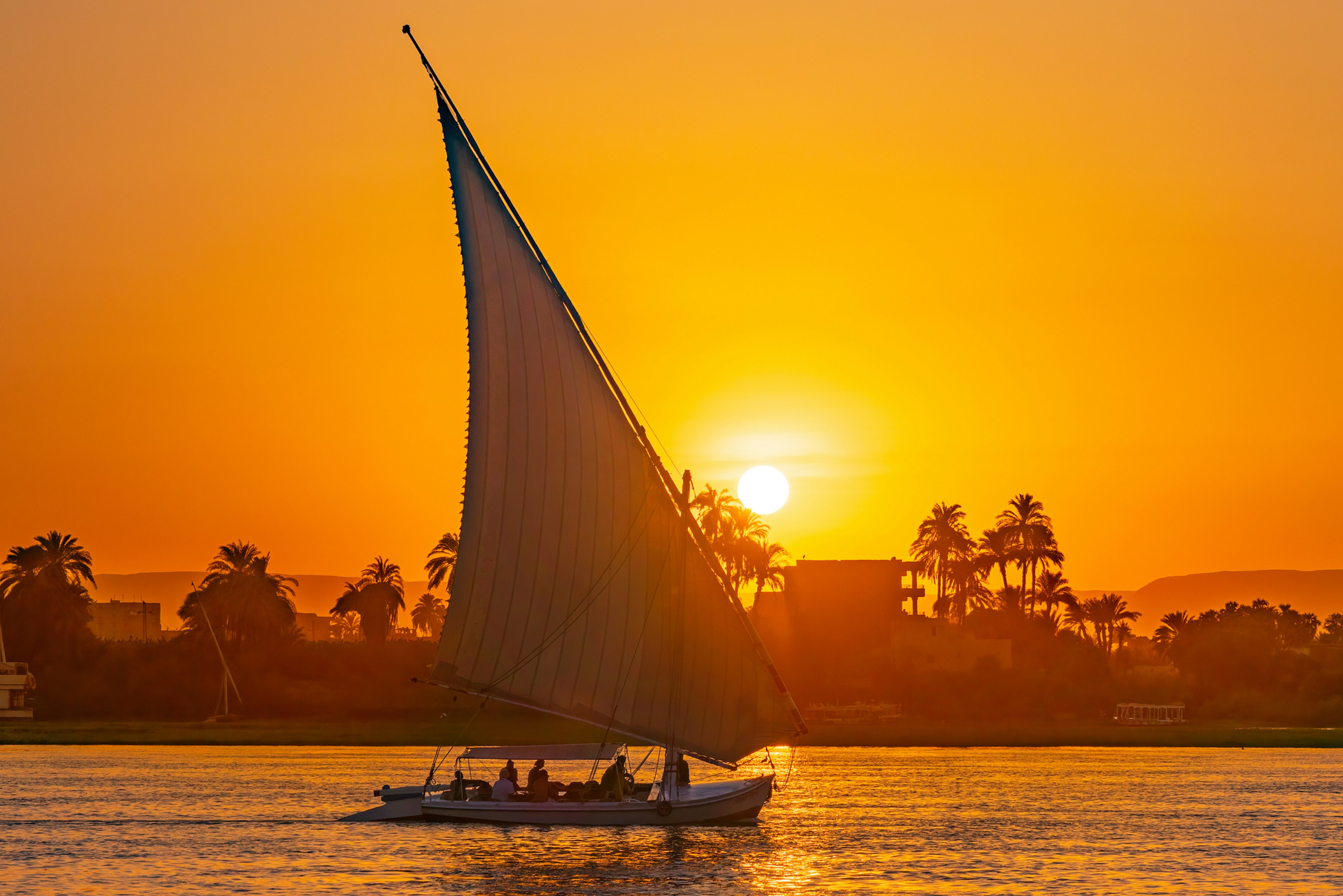 A felucca sails on the Nile at sunset in Luxor, Egypt