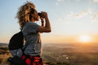 A woman looking through binoculars on a hilltop in Brazil