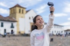 Latina girl with an average age of 7 years dressed comfortably is in the historic square of Villa de Leyva boyaca to which she traveled with her family taking a selfie with her gopro
1446044175