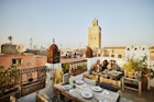 Wide shot of couple taking selfie at rooftop restaurant in Marrakech - stock photo 	© Thomas Barwick / Getty Images