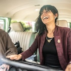 A woman driving a van in Colombia with her friend next to her. They're laughing together