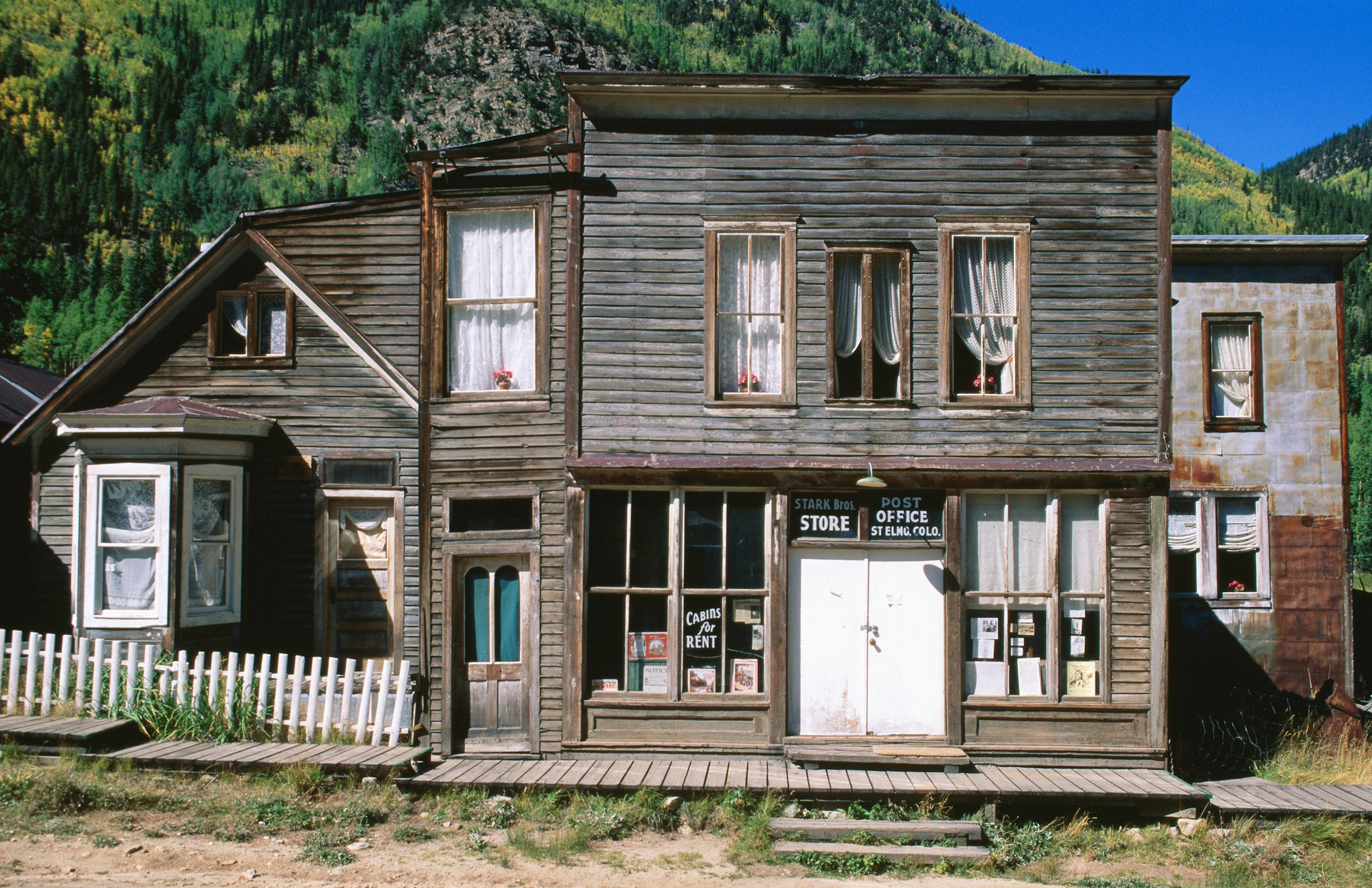 The exterior of a historic wooden-boarded post office building in an abandoned town