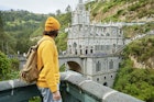 Man with backpack looking towards the Church of Las Lajas, Colombia