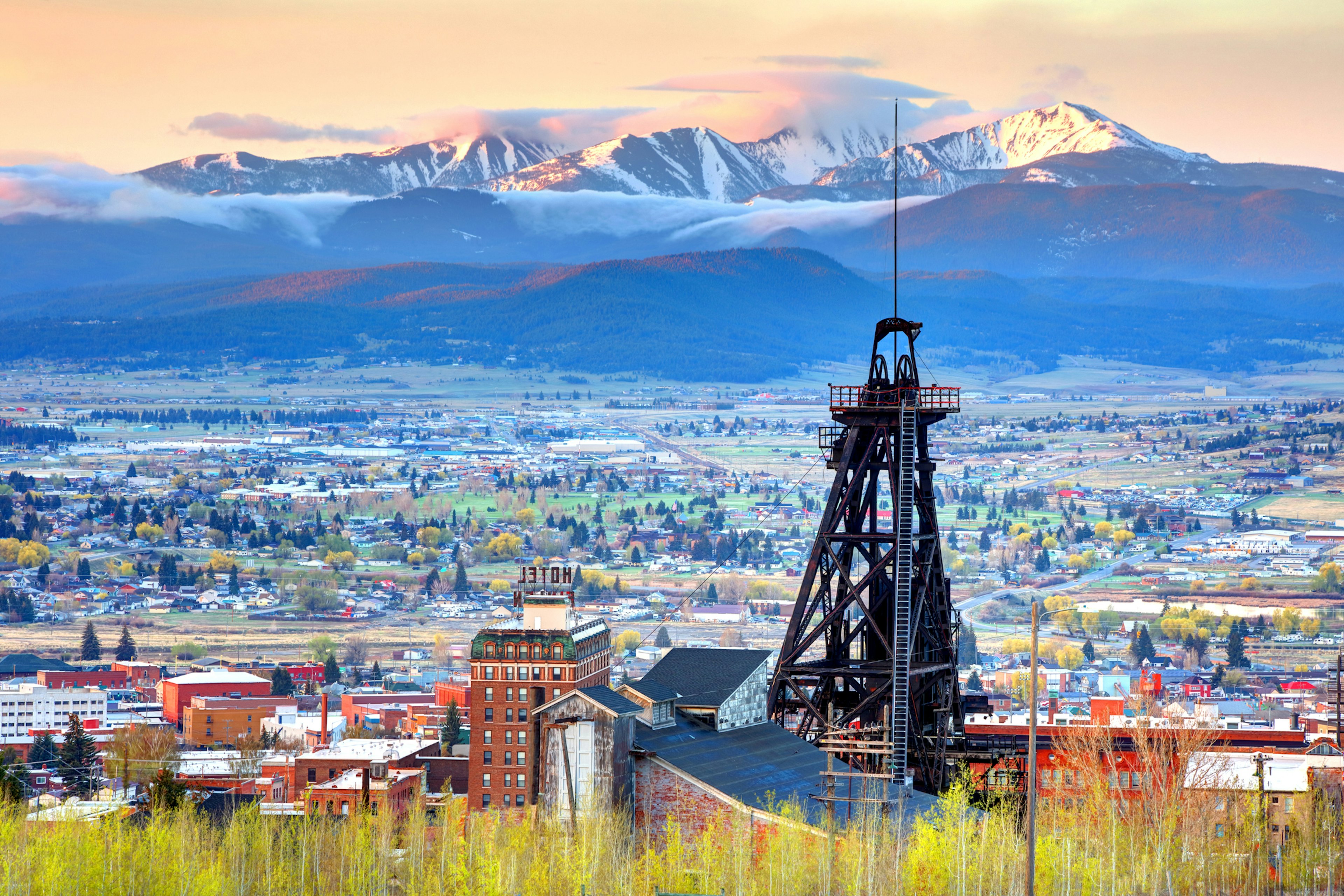 A mining shaft near a town with mountains in the background