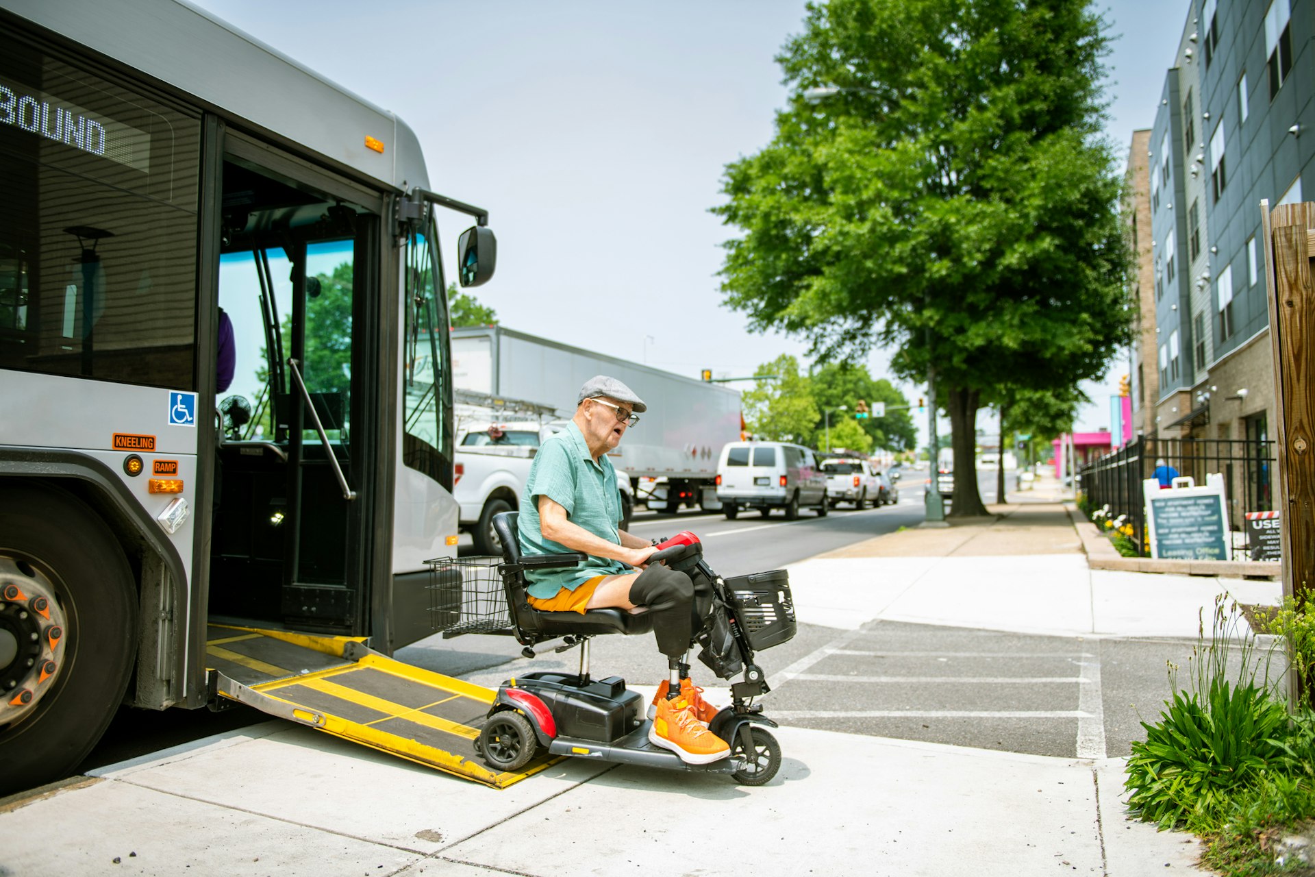 A disabled man in a mobility scooter driving off a bus in the USA