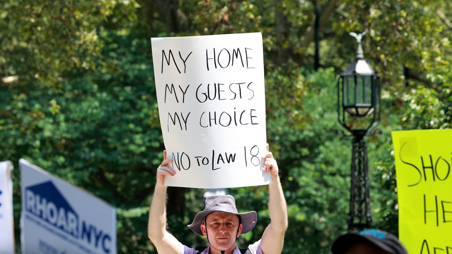 A man holds a placard protesting new regulations limiting short-term rentals, New York City, USA