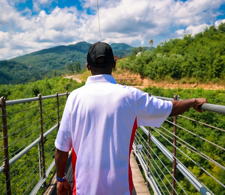 A portrait of a black man walking across a pedestrian bridge in Tennessee © Robin Gentry / Getty Images