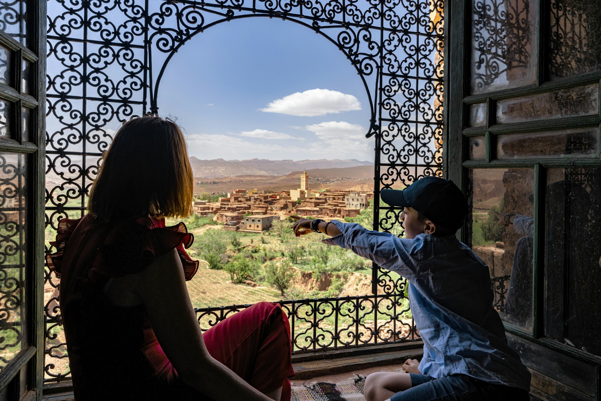 A boy and his mother admiring the famous Telouet Kasbah in the High Atlas mountains, Morocco