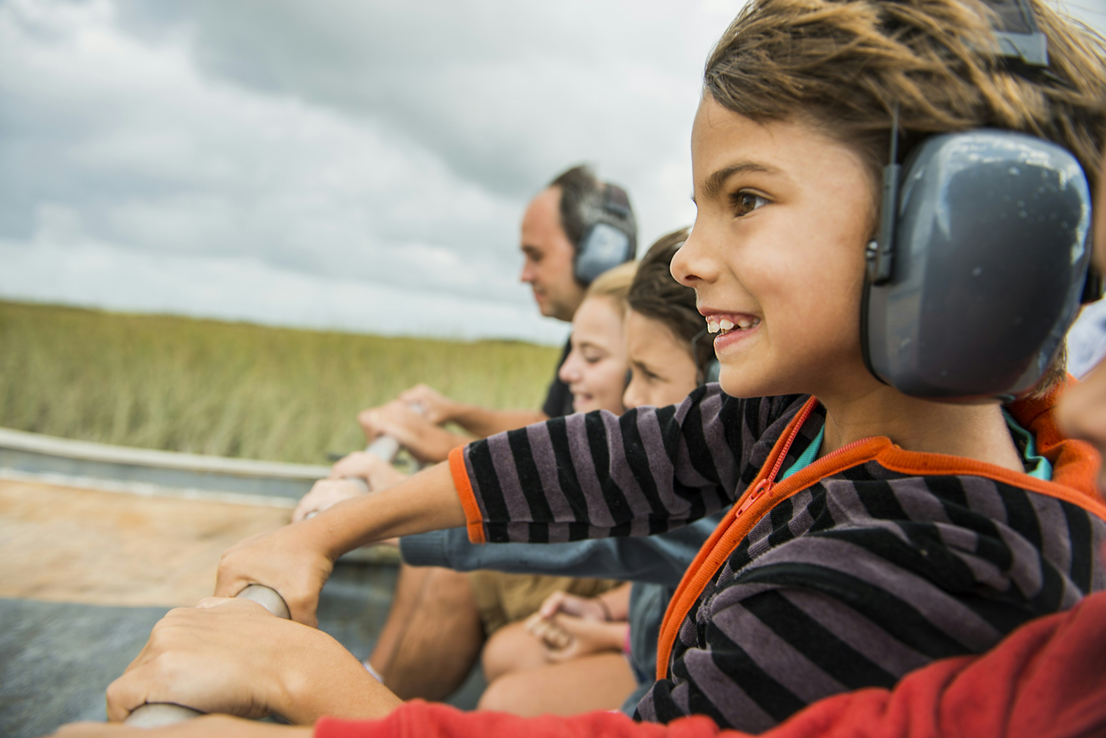 A young boy holding on tight on an airboat in the Florida Everglades