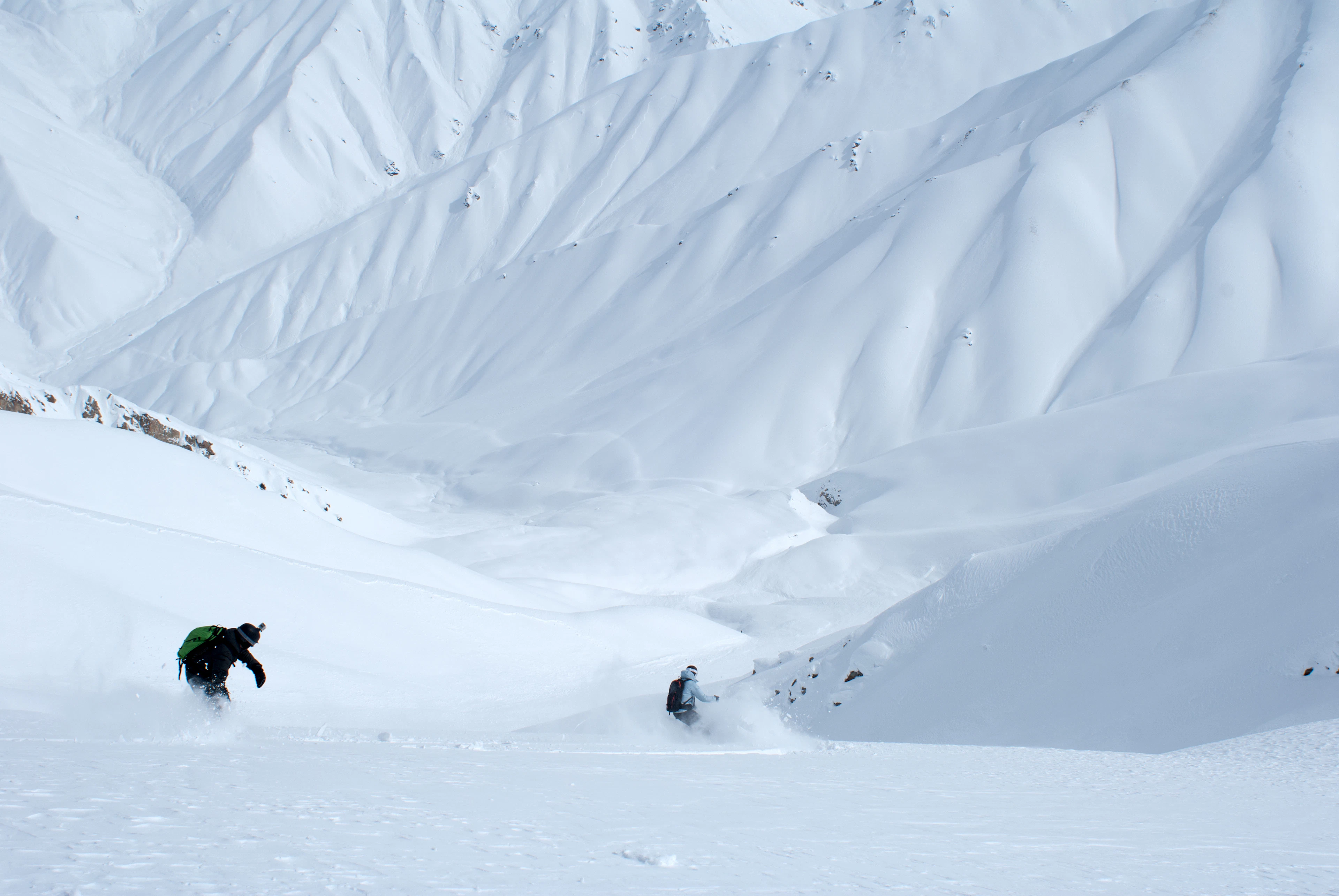 Два лыжника прокладывают пути через горную дикую местность в Узбекистане