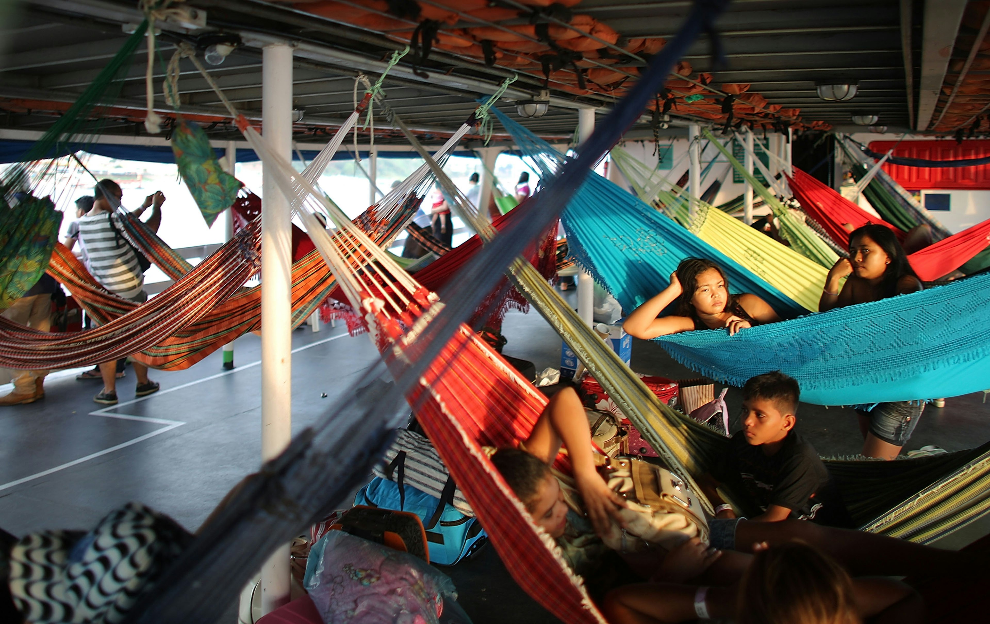 Passengers sit in their hammocks while departing on a transport riverboat in the Amazon from Manaus to Maues, Brazil