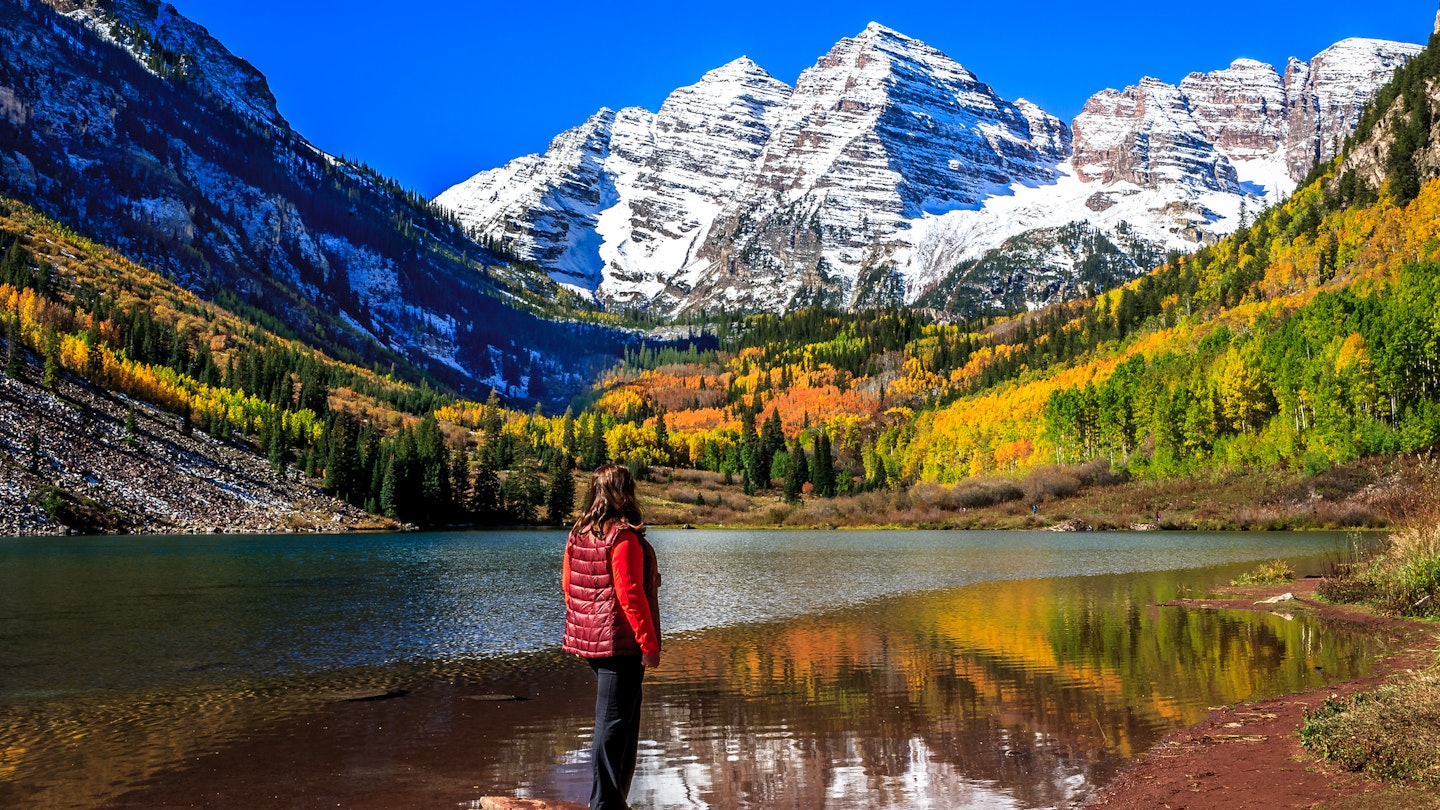 A woman stands on a rock on Maroon Lake admiring the autumnal beauty of the Maroon Bells in a sunny, cloudless day
473641514
Tourism, Wilderness Area, Morning, Non-Urban Scene, Extreme Terrain, Women, Females, Elk Mountains, National Forest, Maroon Lake, Snowcapped, Maroon Bells, Aspen Tree, Scenics, Rocky Mountains, Majestic, Idyllic, Tranquil Scene, Famous Place, High Up, Nature, Outdoors, Colorado, Western USA, USA, Leaf, Reflection, Alpenglow, Autumn, Mountain Peak, Mountain, White River National Forest, Forest, Landscape, Lake, Glacier, Snow, North Maroon Peak, South Maroon Peak