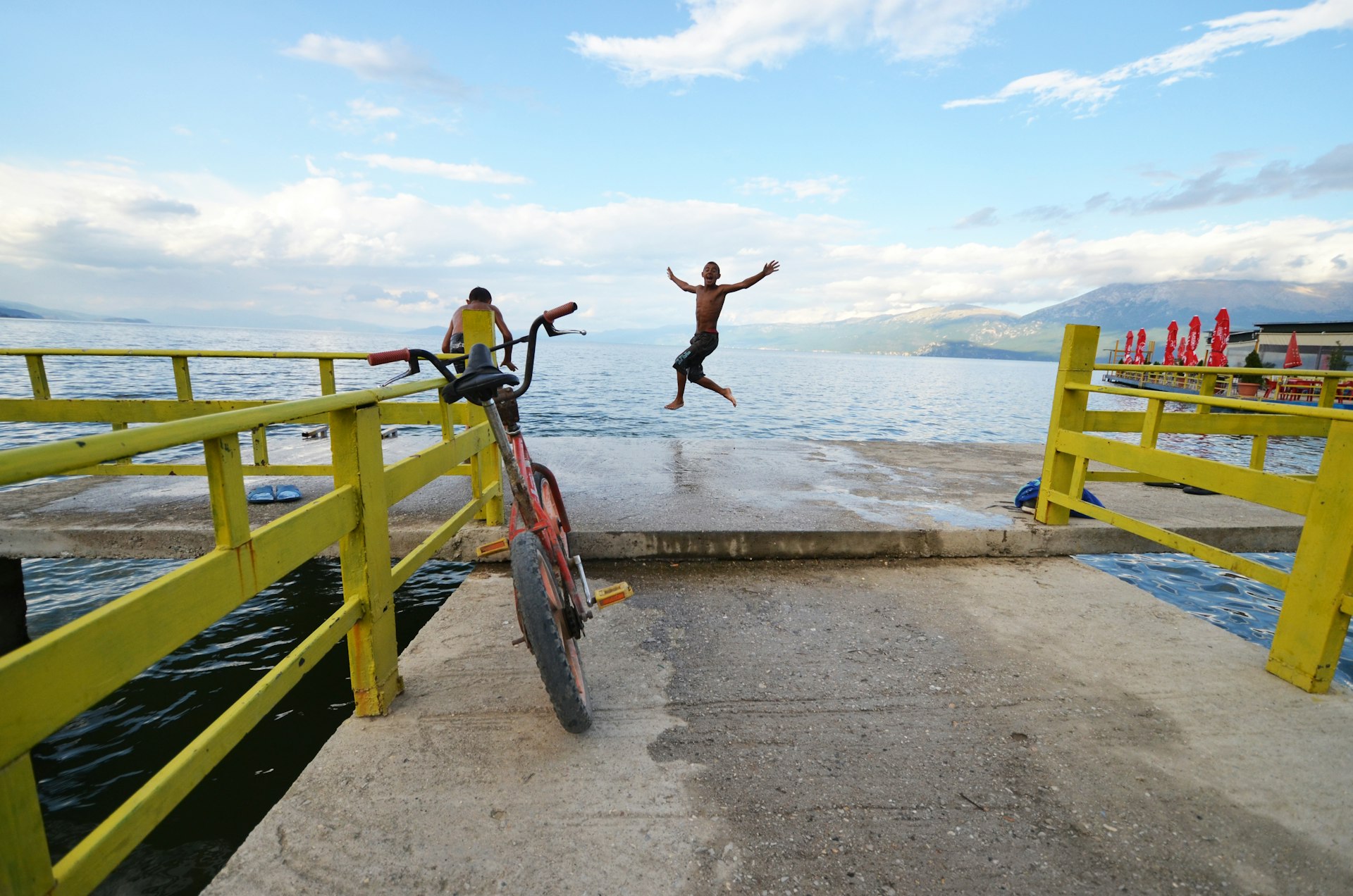 A boy jumps into the water from a pier in a Lake Ohrid, Pogradec, Albania
