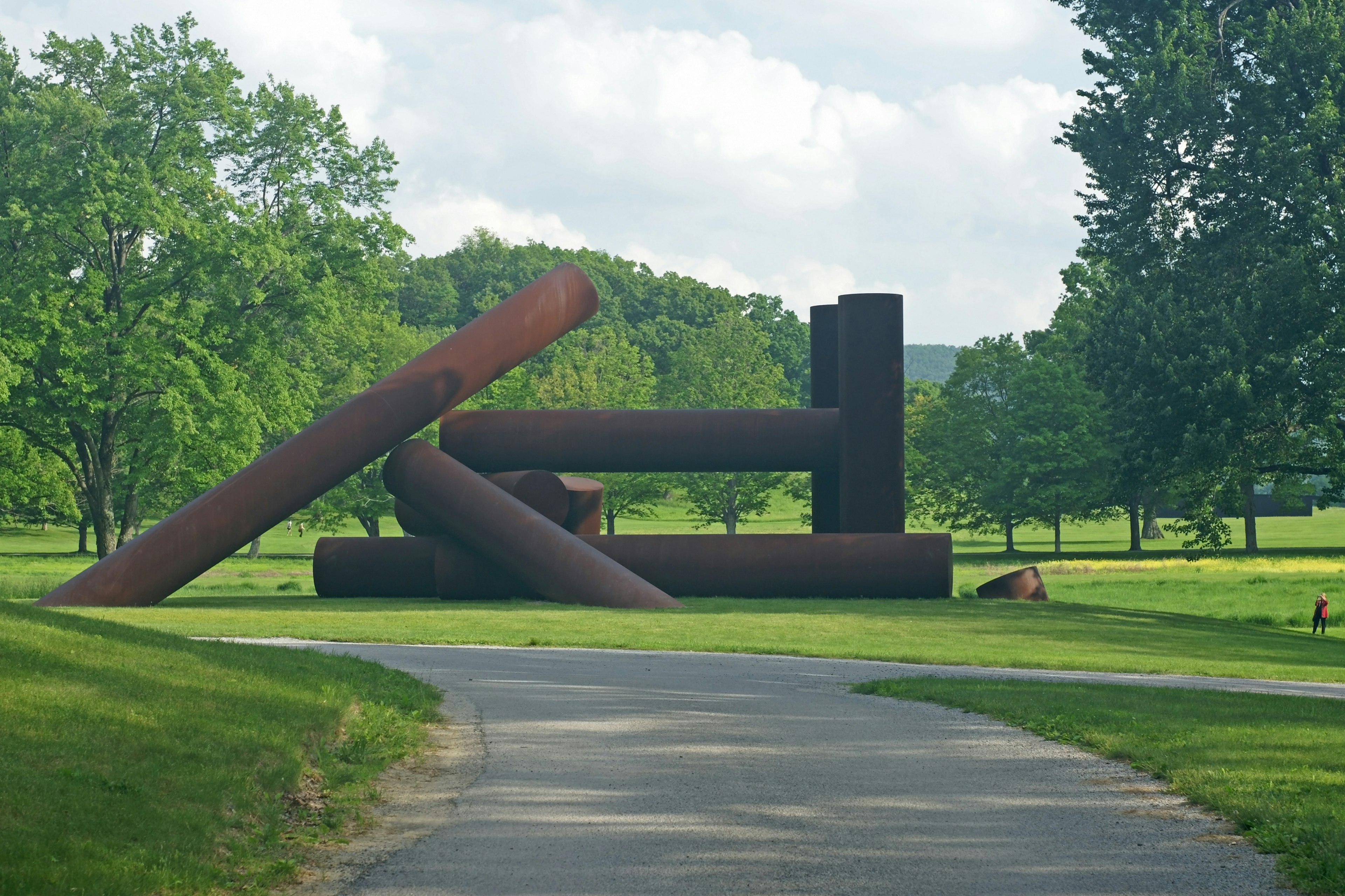 Visitor walking around the field at Storm King Art Center, an outdoor art gallery near New York City.