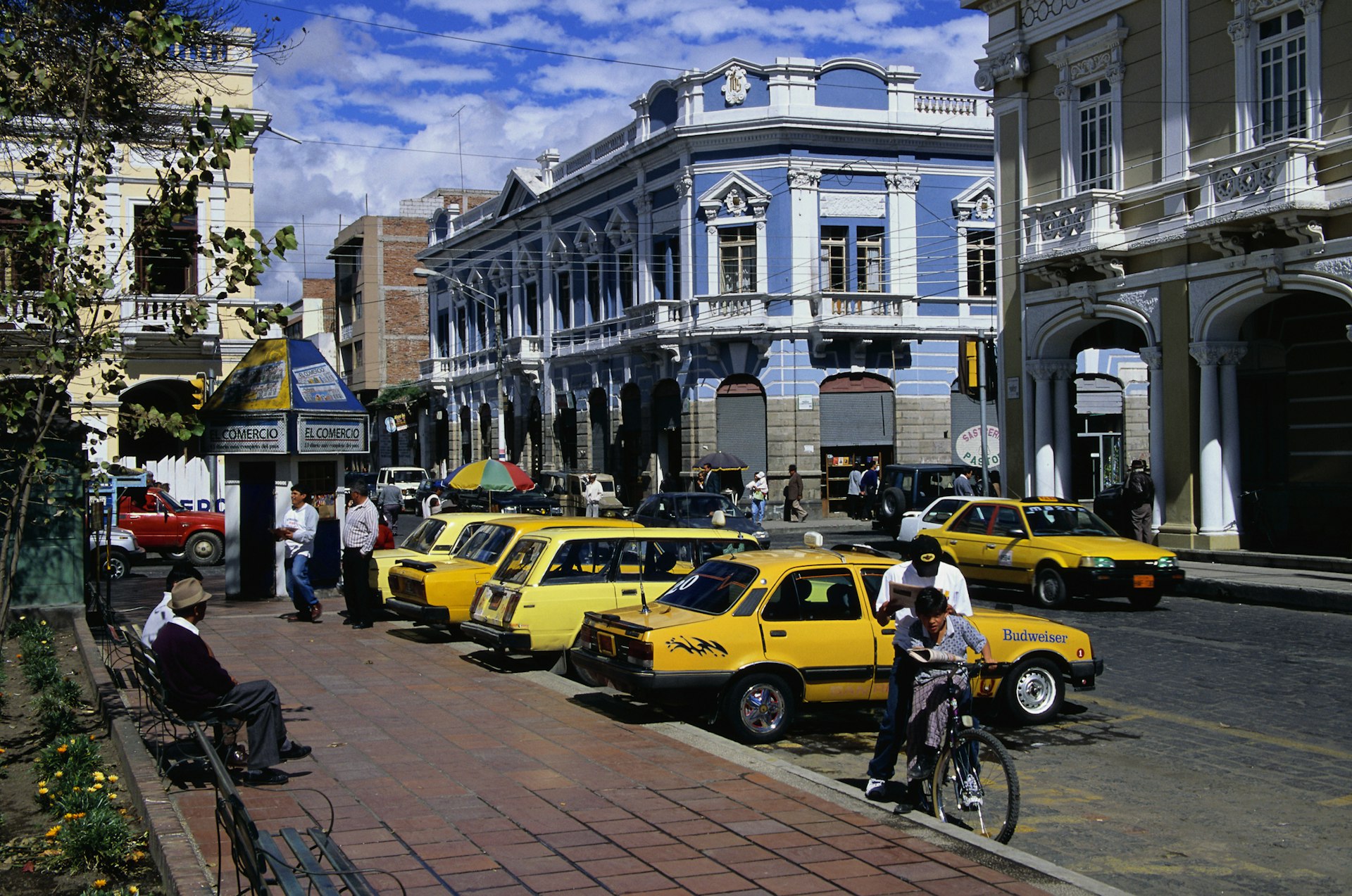 Yellow taxis parked in a line next to the sidewalk in Riobamba, Ecuador 