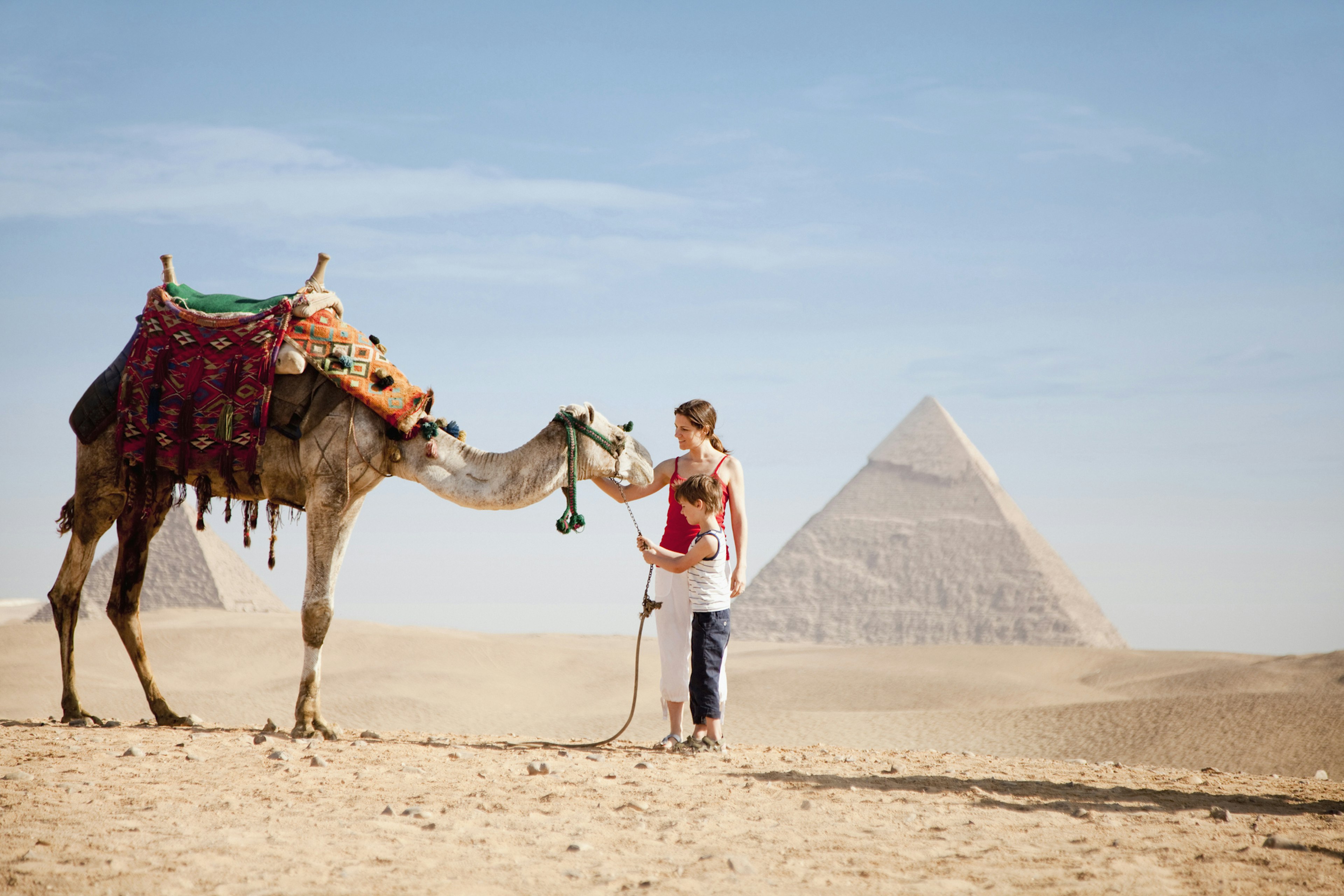 Mother and son with a camel at the Pyramids of Giza, Egypt