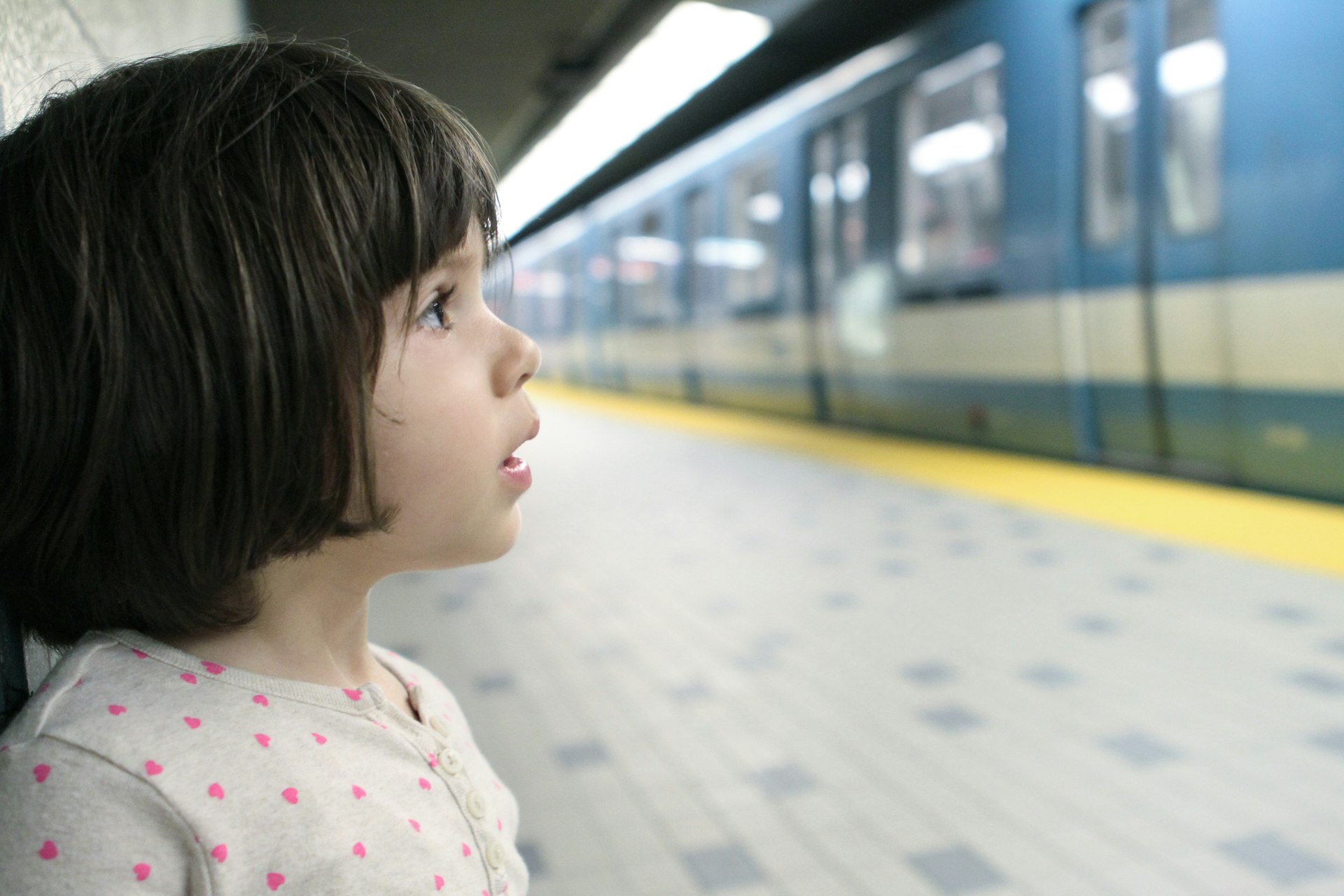 A girl looks at a metro train in a station in Montréal, Québec, Candada