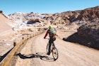 A man riding a mountain bike through the Valle de la Luna, Atacama Desert, Chile
