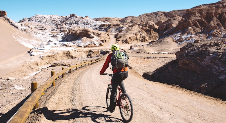 A man riding a mountain bike through the Valle de la Luna, Atacama Desert, Chile