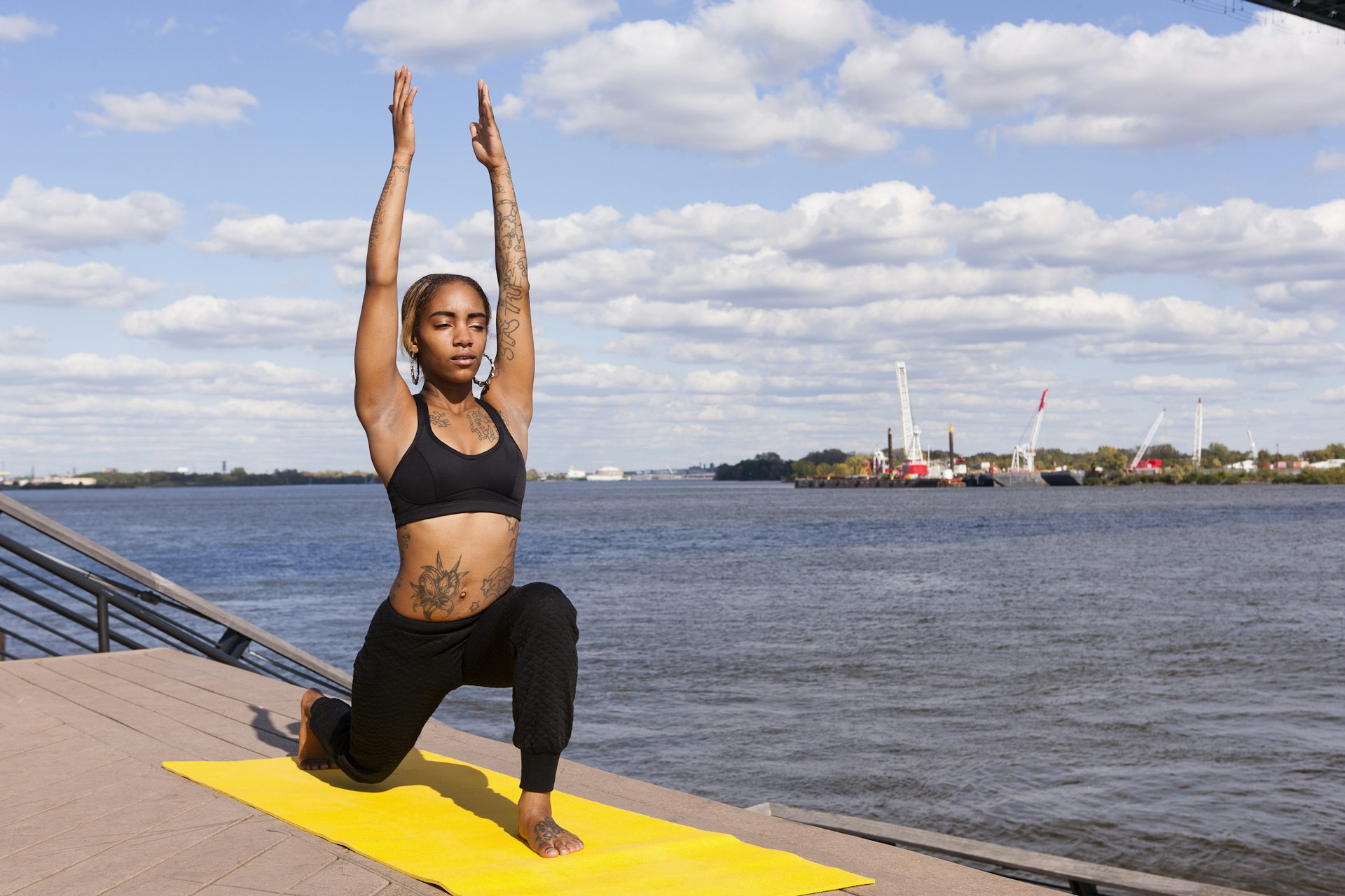 A beautiful black woman doing yoga outside by the river in Philadelphia, PA.