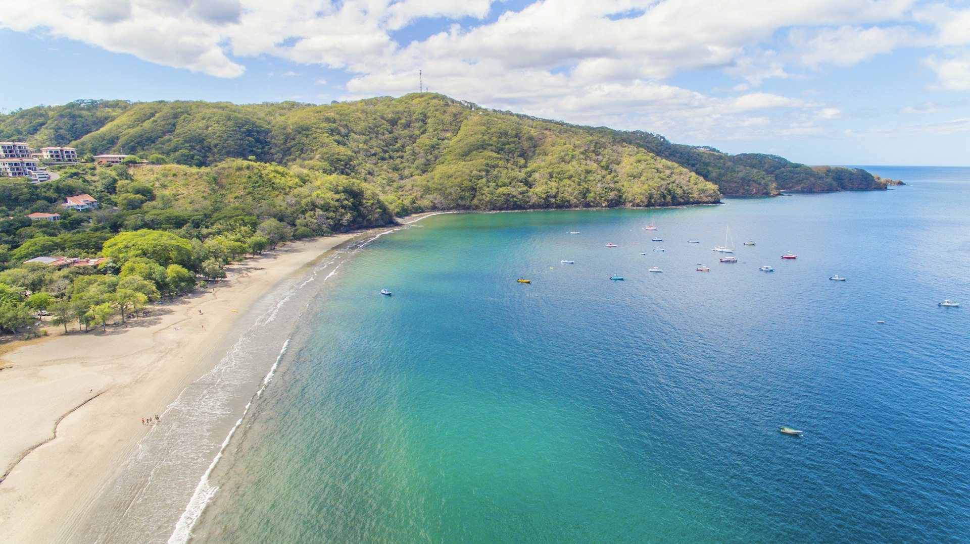 An aerial view of turquoise water and white sand at Playa Hermosa in Costa Rica
