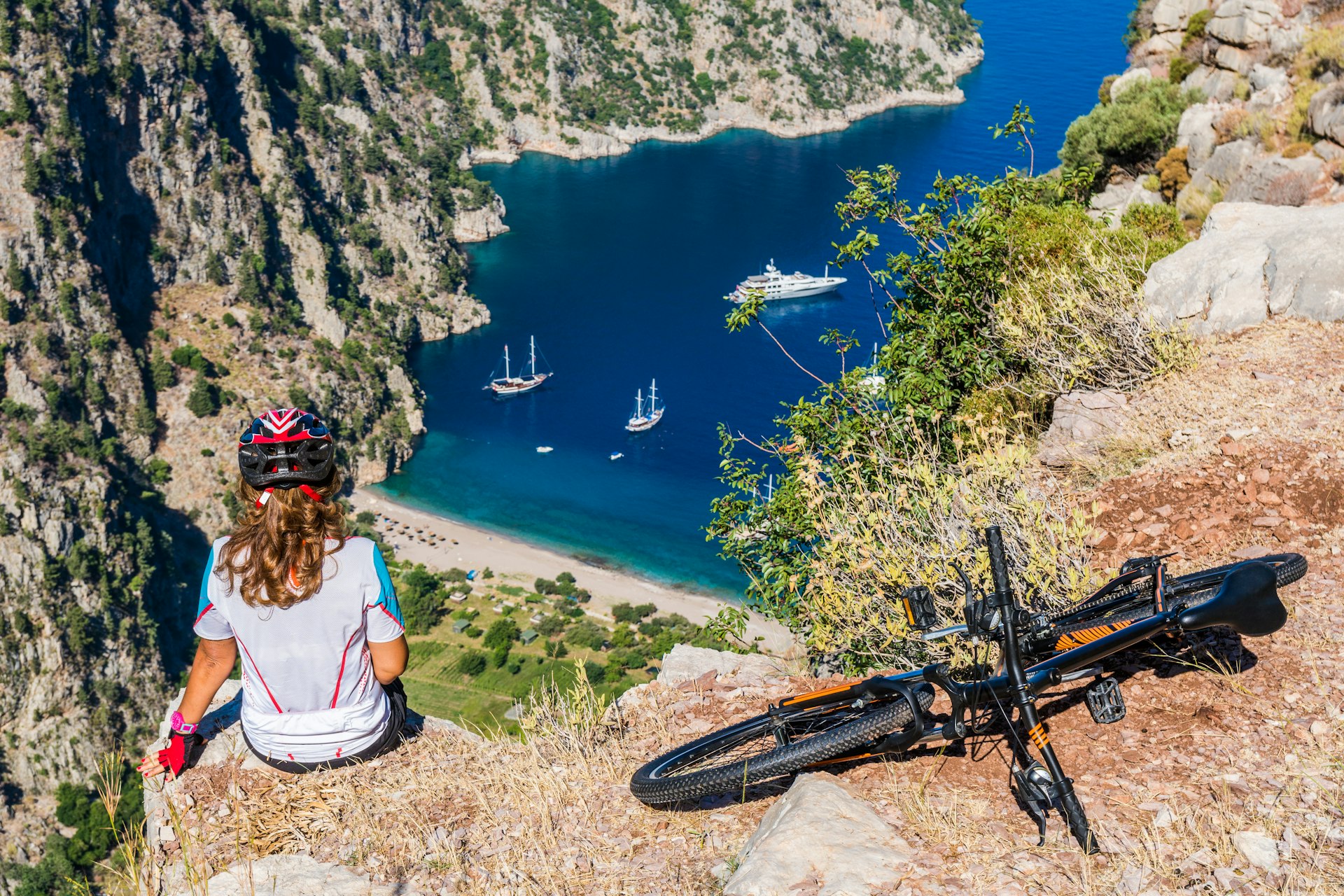 A cyclist stops to look down at Butterfly Valley, Oludeniz, Fethiye, Turkey