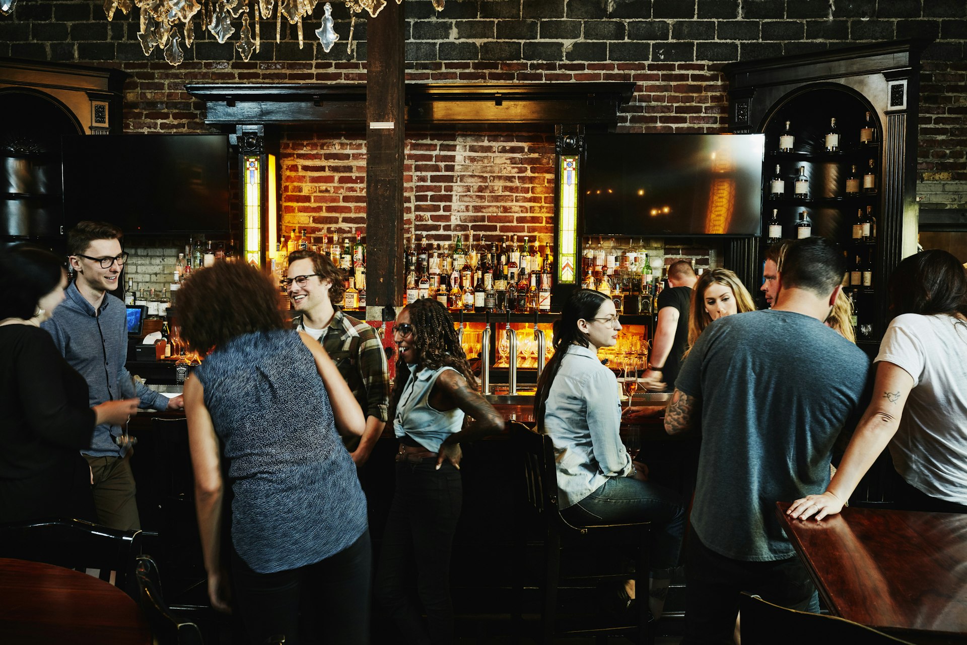 Group of friends sharing drinks in busy bar in Washington state, USA