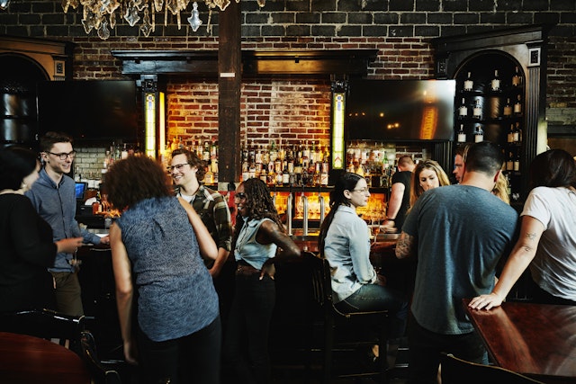 Group of friends sharing drinks in busy bar in Washington state, USA