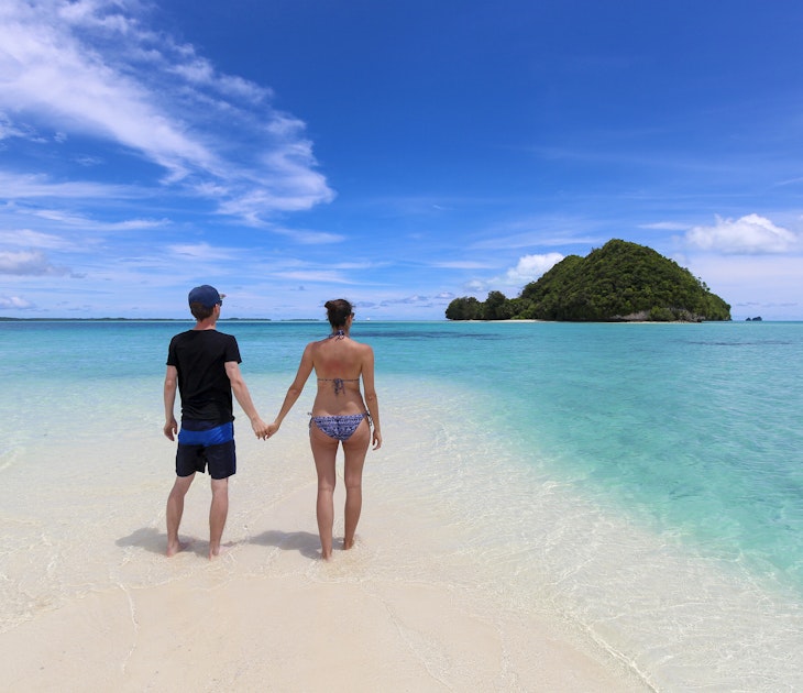 Palau - July 2017: young couple enjoying the view on Long Beach with one of the many islands of Palau in the background, surrounded by clear water in turquoise and blue colors
854284974
A couple standing on Long Beach in Palau surrounded by clear blue ocean and islands in the background.
