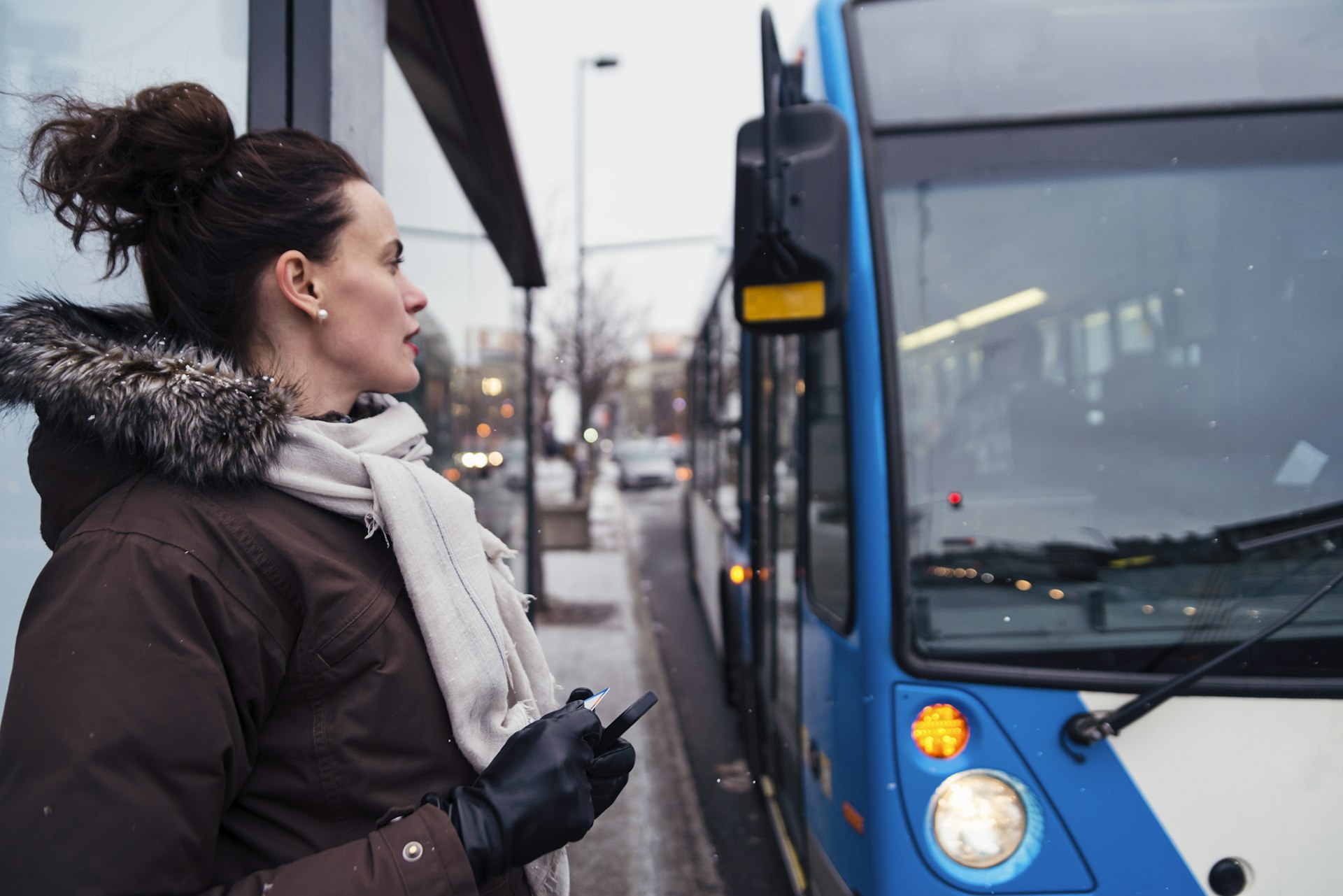 A woman waits for an approaching bus in Montréal, Québec, Canada