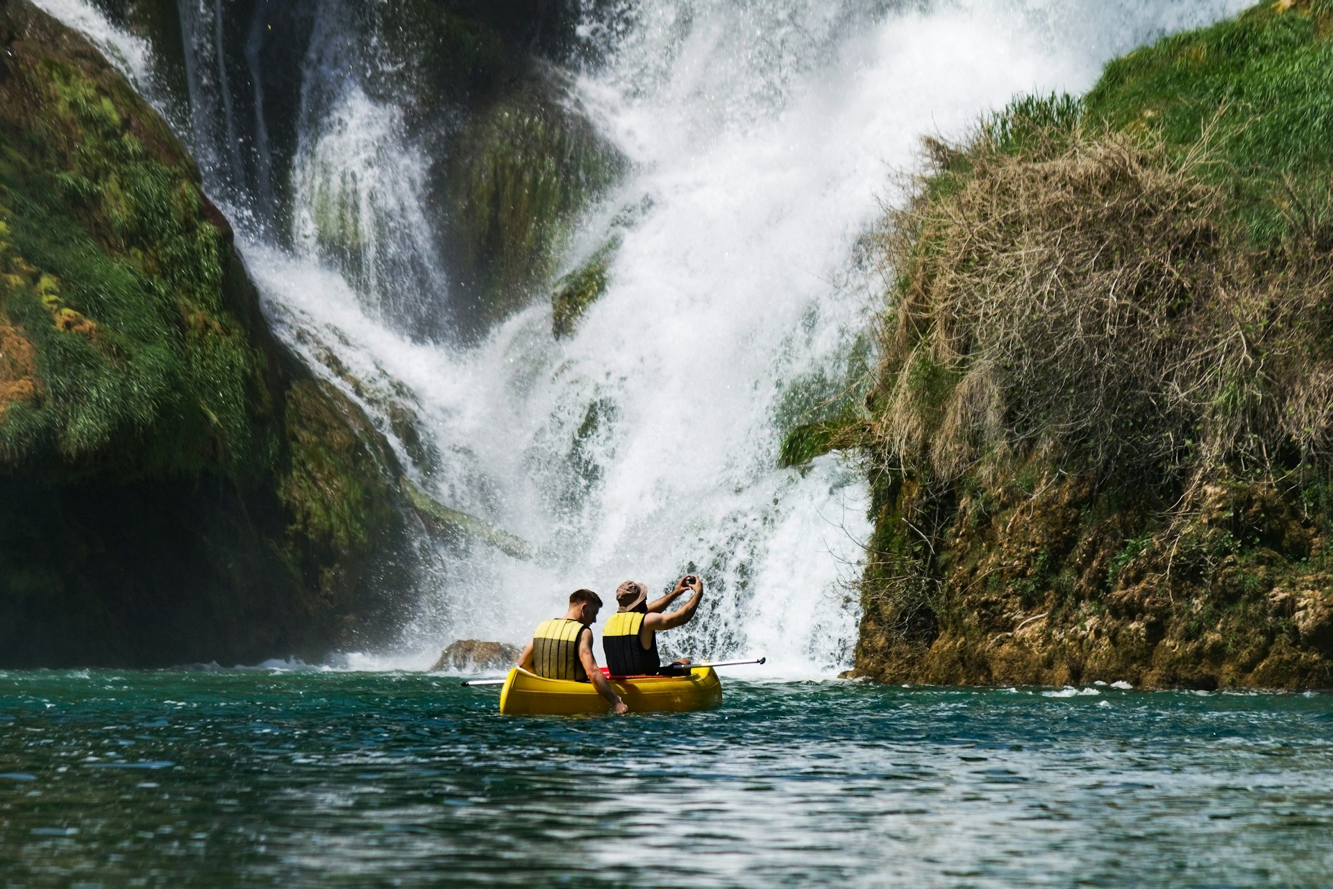 Two people in a canoe at Kravice Waterfall, Bosnia & Hercegovina