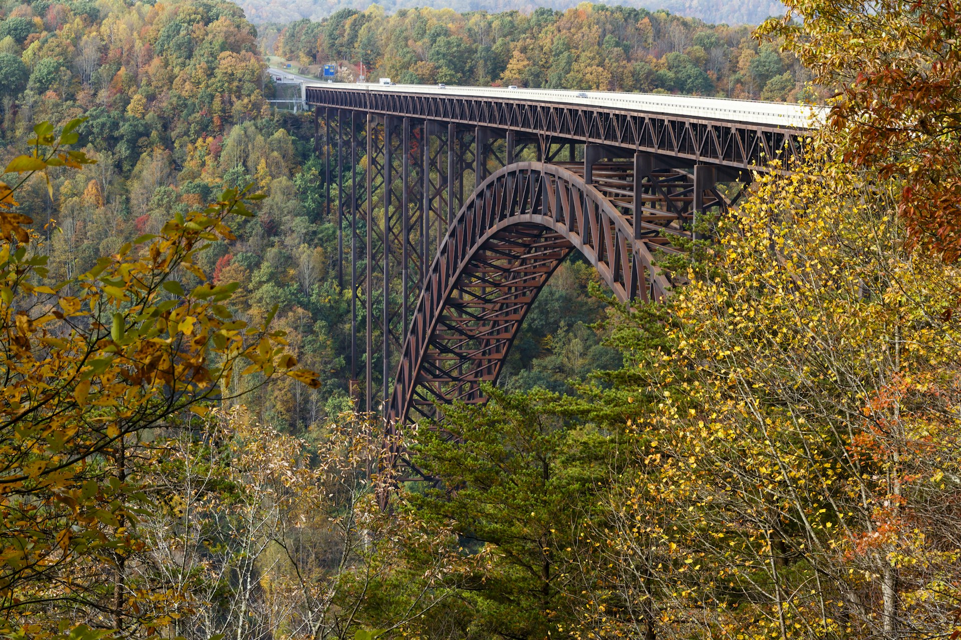 Cars driving across The New River Gorge Bridge in West Virginia on a crisp autumn day