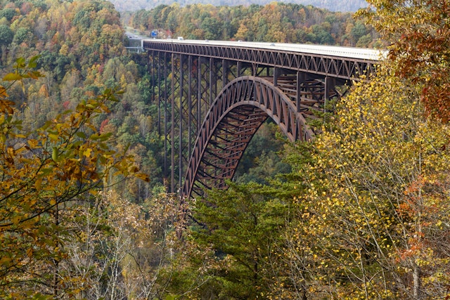 Cars driving across The New River Gorge Bridge in West Virginia on a crisp autumn day