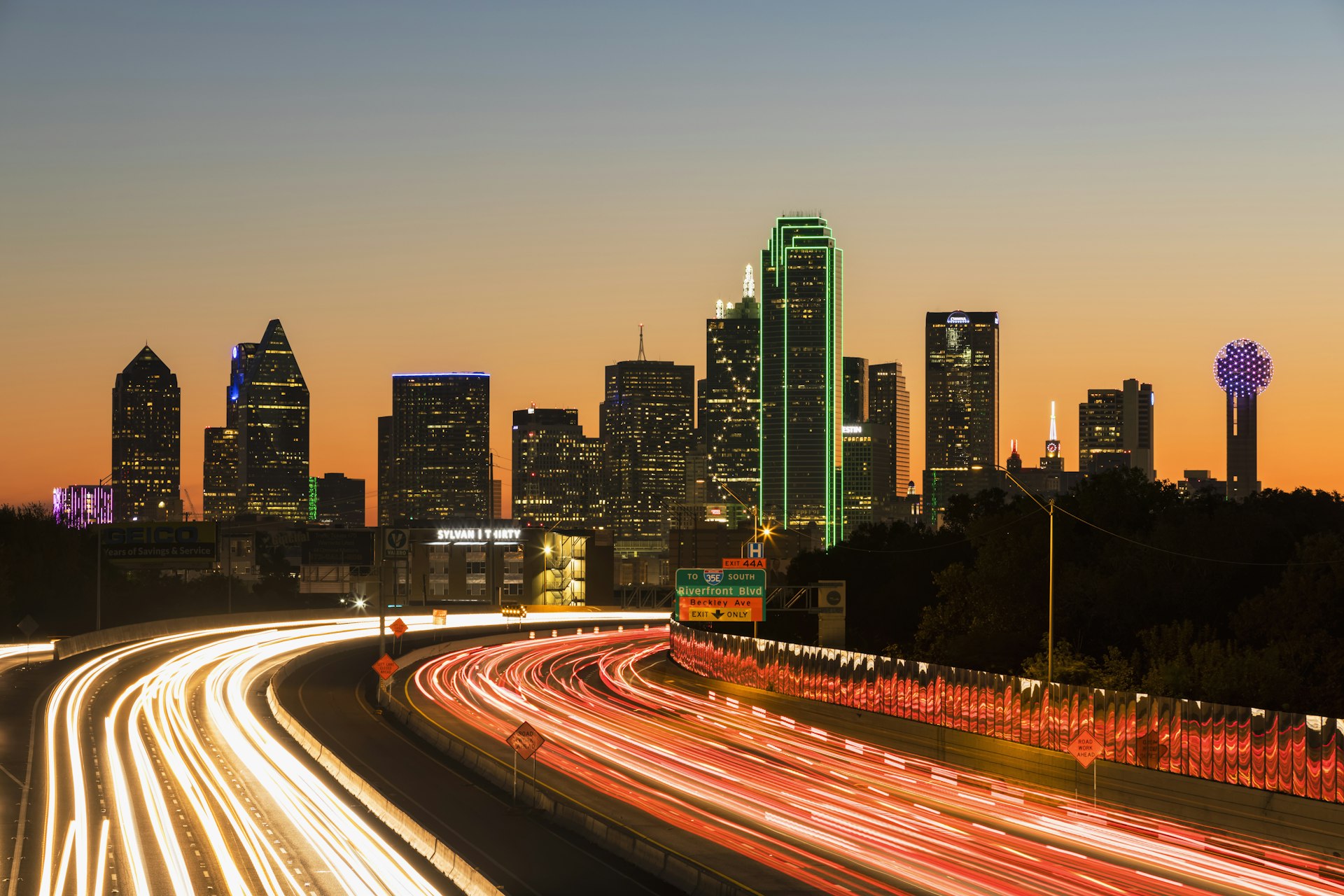 Traffic on the Tom Landry Freeway at night with the Dallas skyline