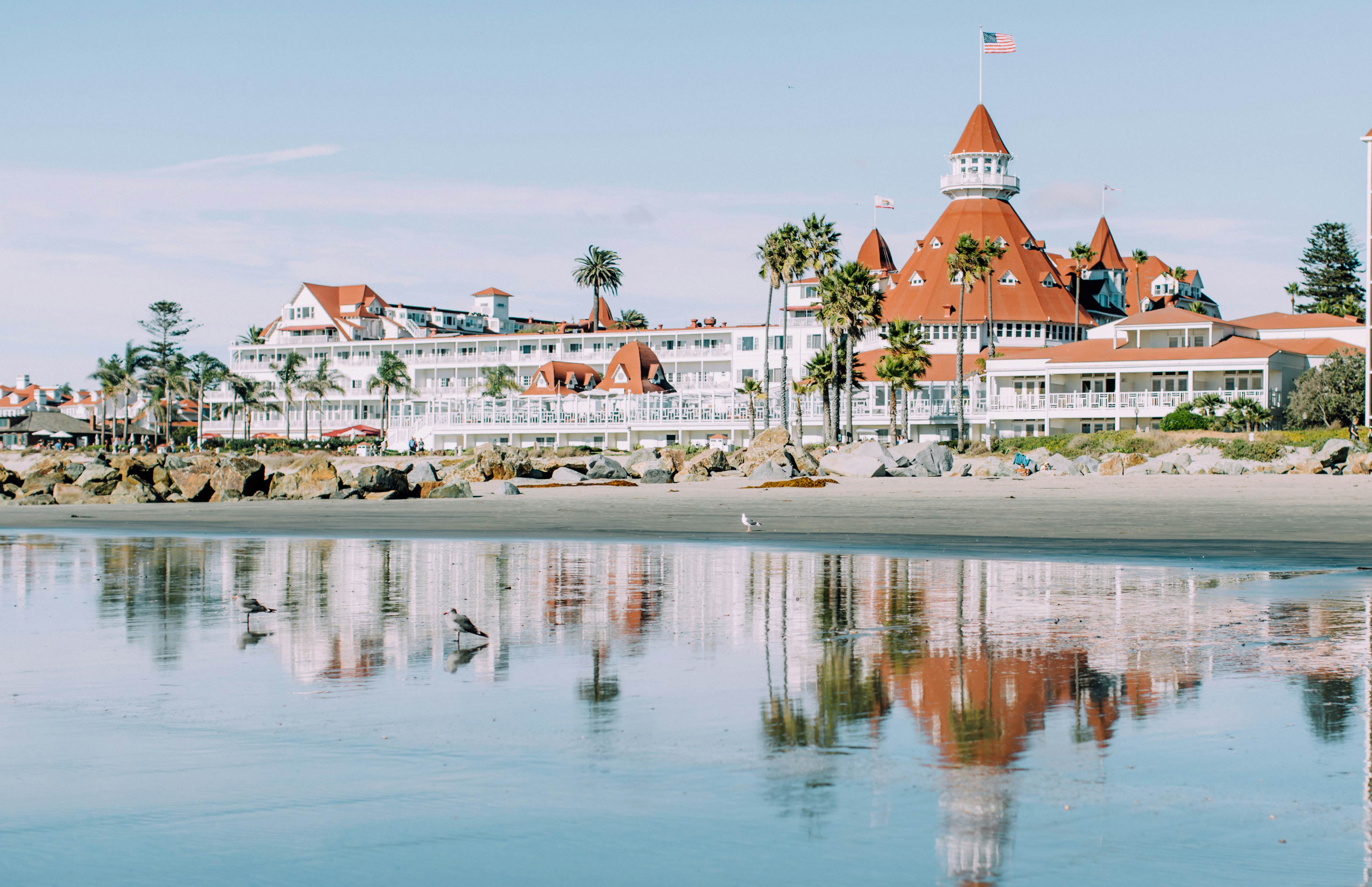 A beachside hotel – big and white with red roofing and palm trees