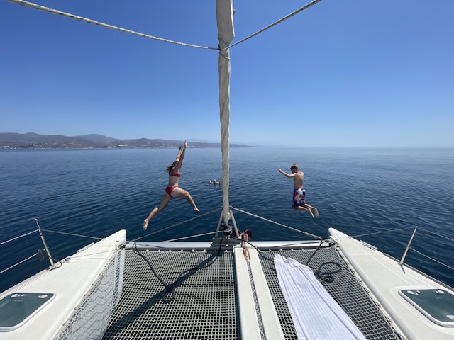 A boy and girl jump into the ocean off of the back of a sail boat. IMG0383.jpeg