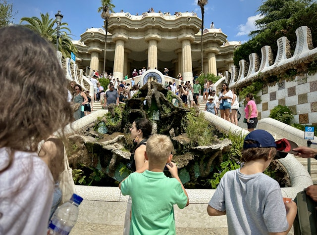 A boy stands on some steps and snaps a photo of a fountain at Parc Güell in Barcelona. IMG1378.jpg