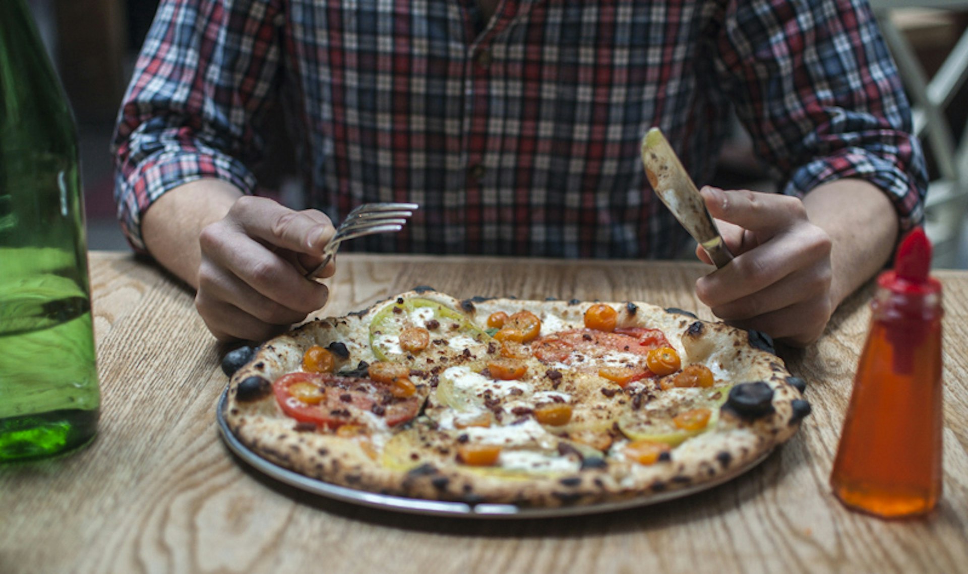 Man eats a pizza with a knife and fork