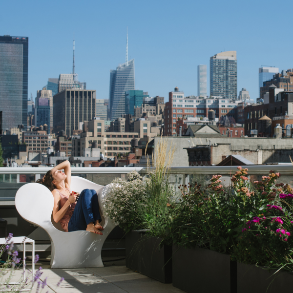 NYC skyline and woman sitting on rooftop