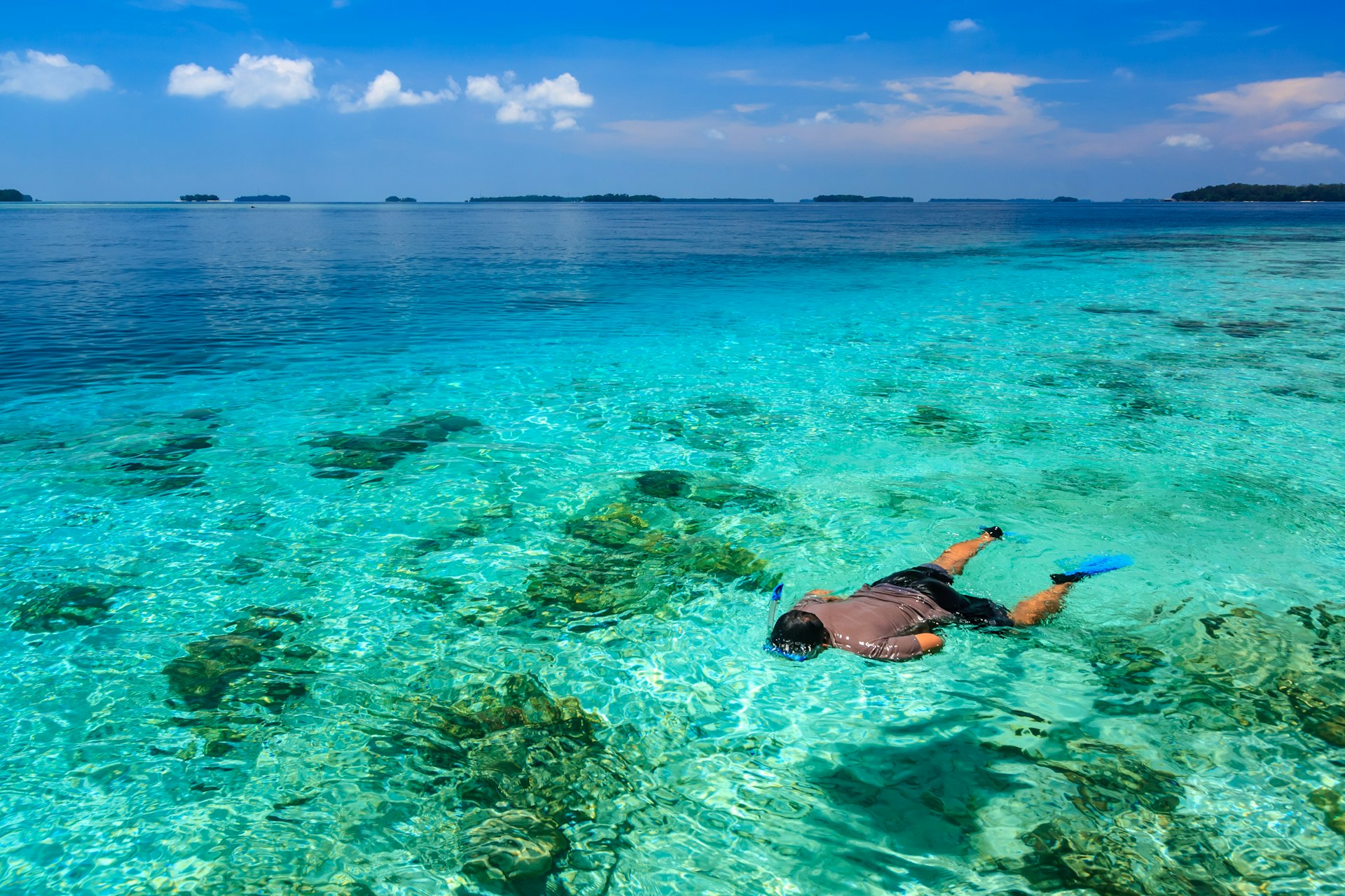 A snorkeler in the blue waters of the Thousand Islands near Jakarta