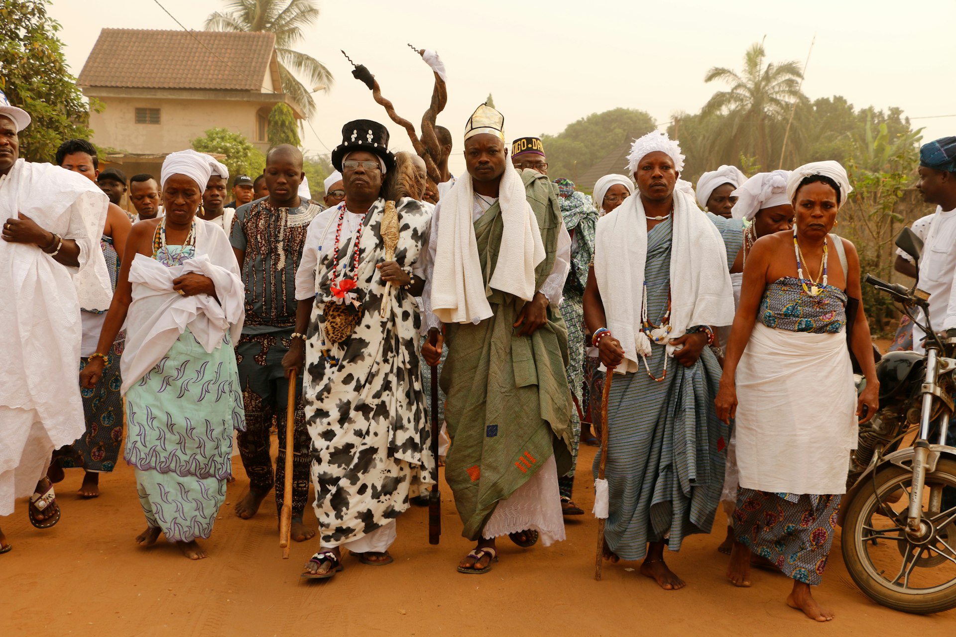 A group of people walking with priests at a Voodoo celebration in Ouidah, Benin