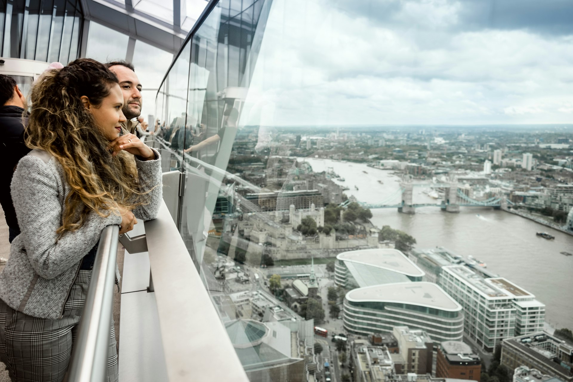 A young couple of tourist enjoying skyline of London from the viewing deck of a very tall building