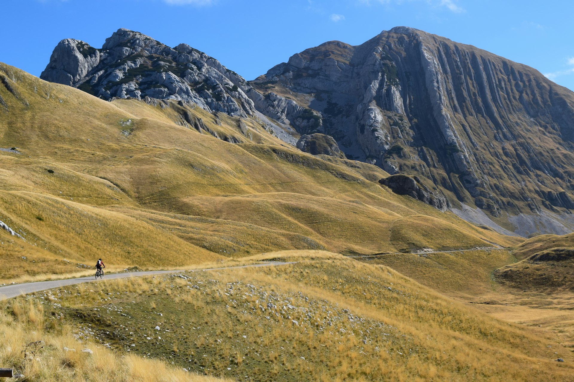 Lone cyclist rides on a road in the mountains, Montenegro